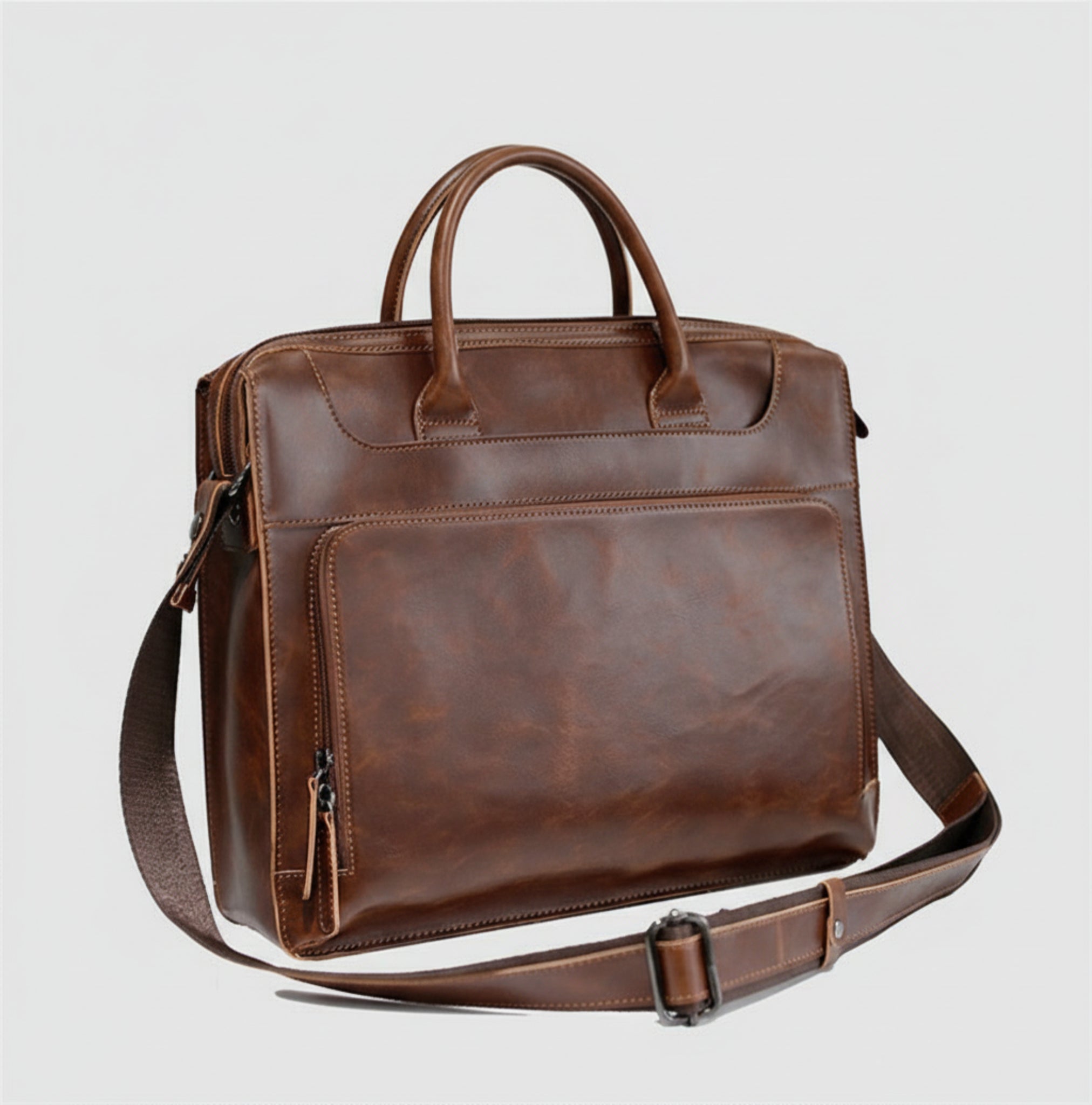 Brown leather briefcase with shoulder strap on a white background