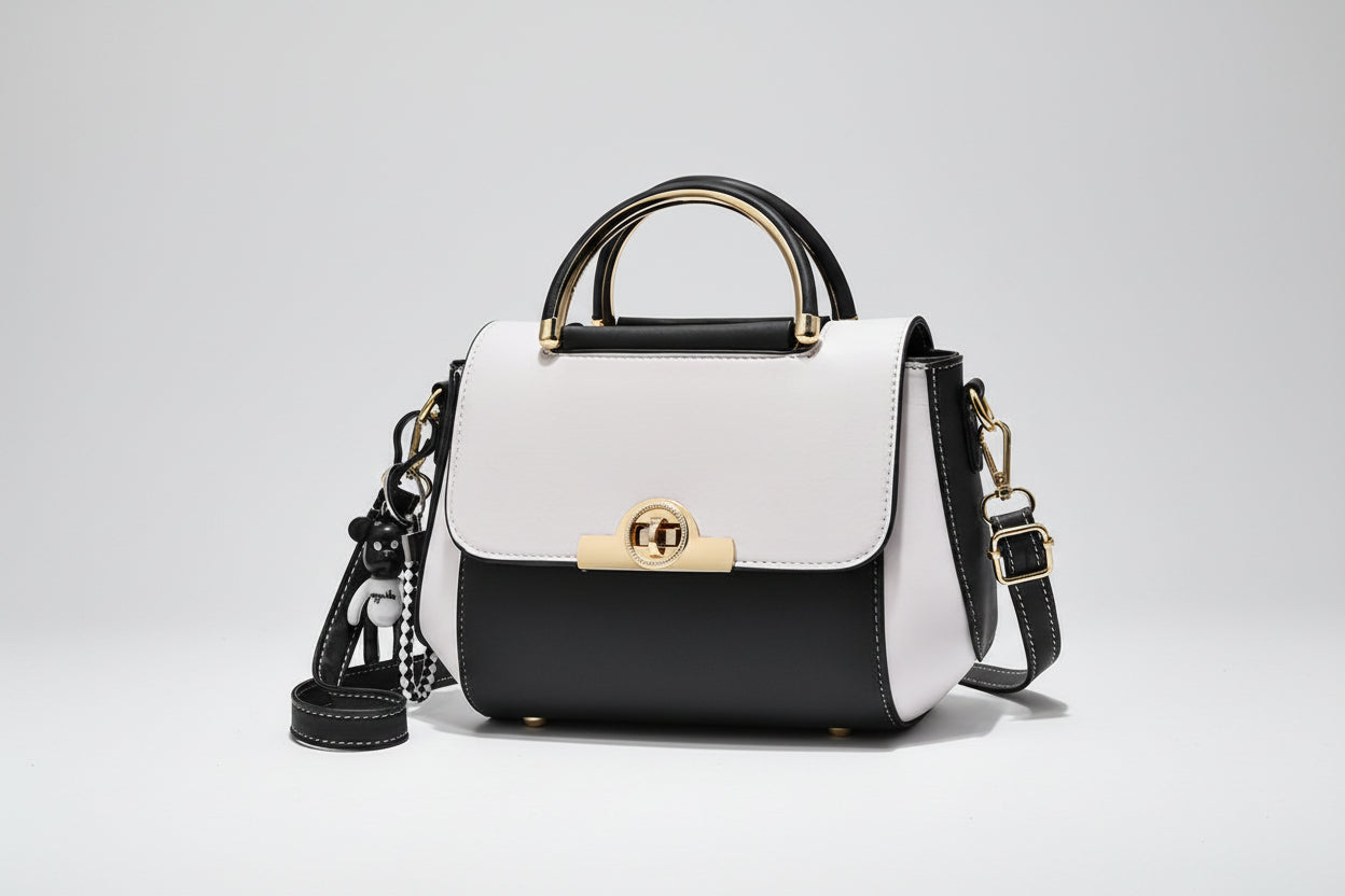 Black and white handbag with gold accents on a white background
